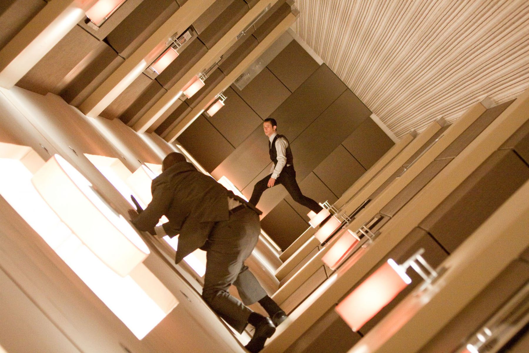 A man in a suit walking down a hallway.